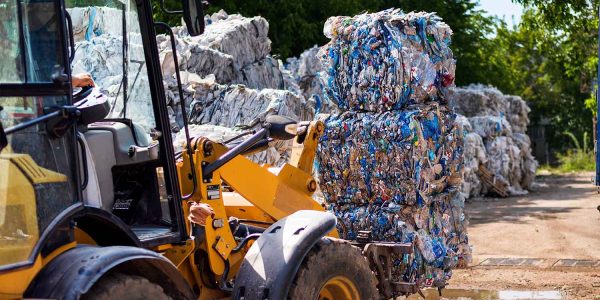 excavator-working-at-a-plastic-recycling-factory-QK3GJBH.jpg
